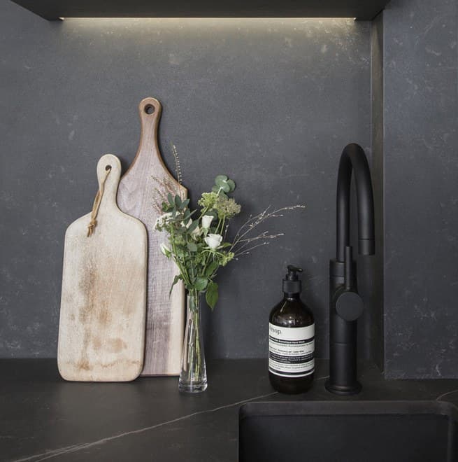 Dark worktop and splashback with wooden chopping boards